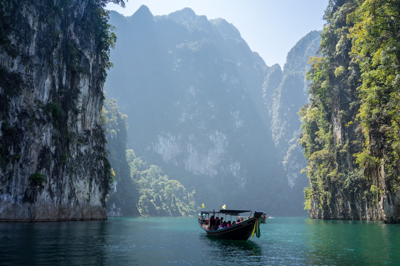 Turquoise water and white sand beach lined with palm trees in Thailand
