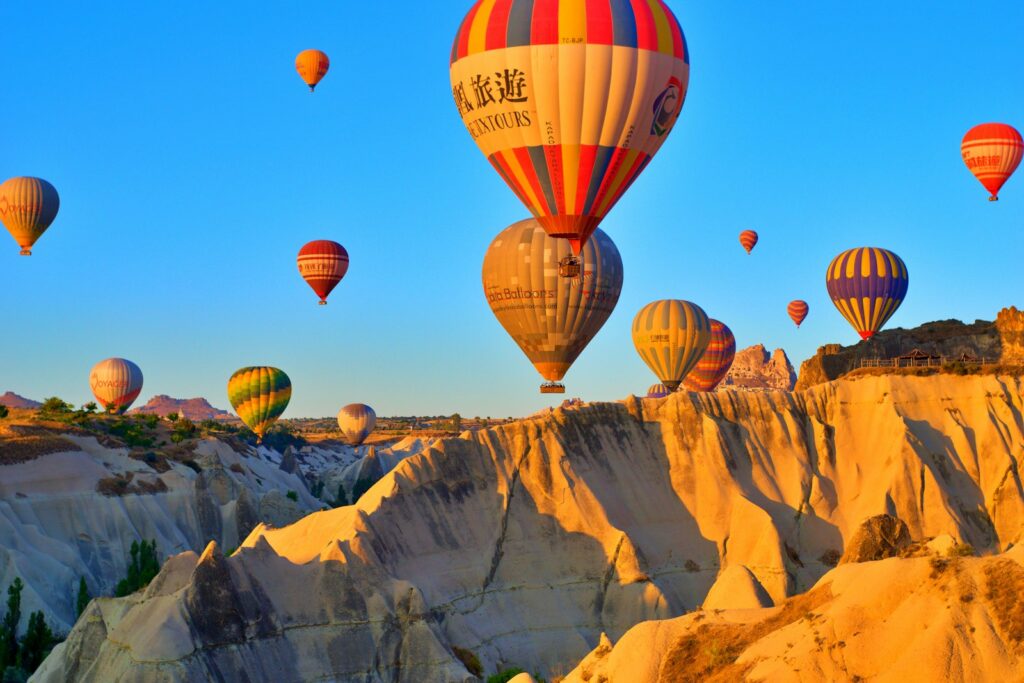 Hot air balloons rising at sunrise over the fairy chimneys of Cappadocia