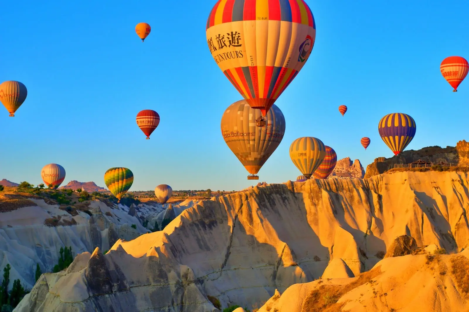 Hot air balloons rising at sunrise over the fairy chimneys of Cappadocia