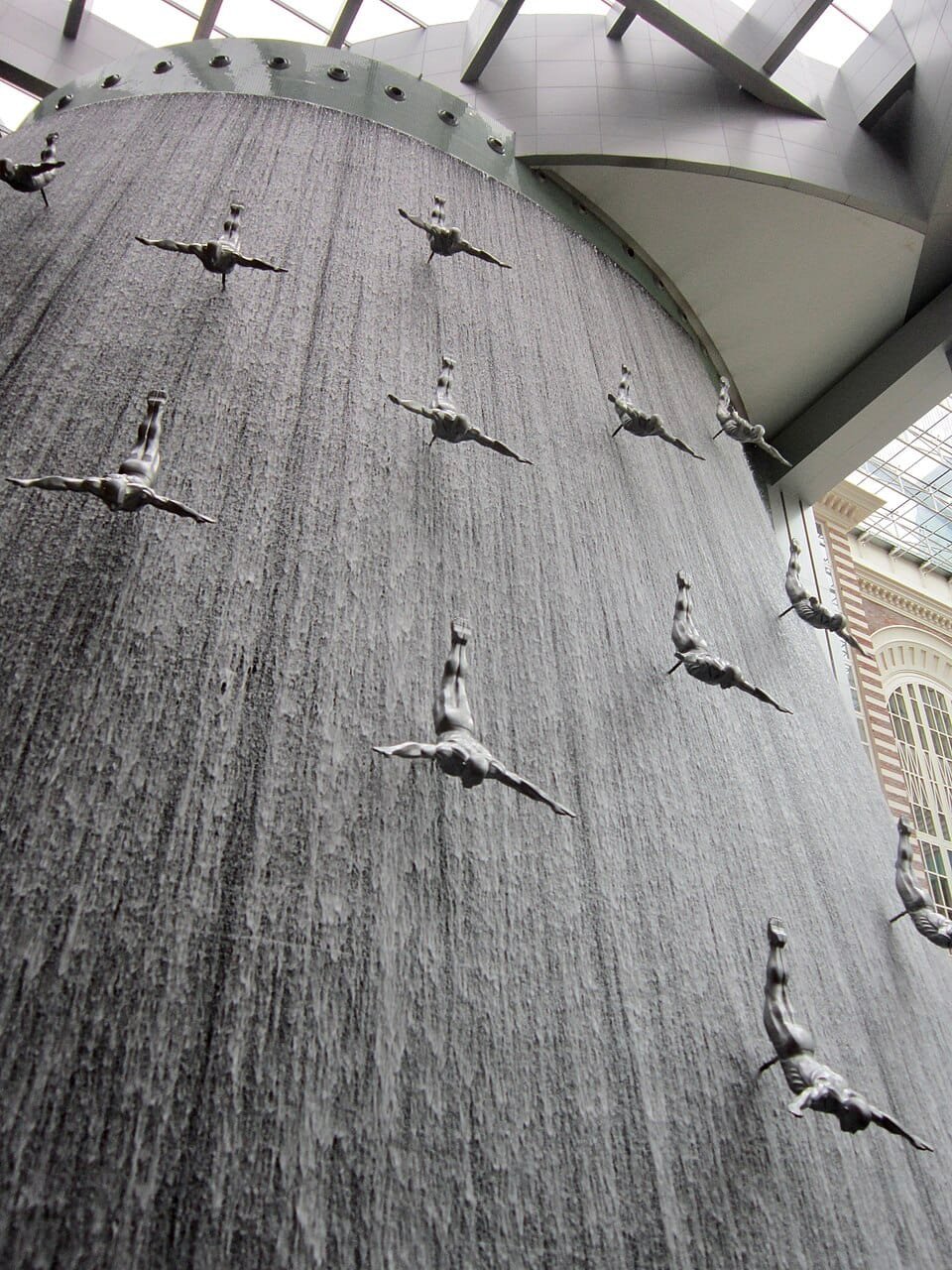 Indoor waterfall with diver sculptures in mall