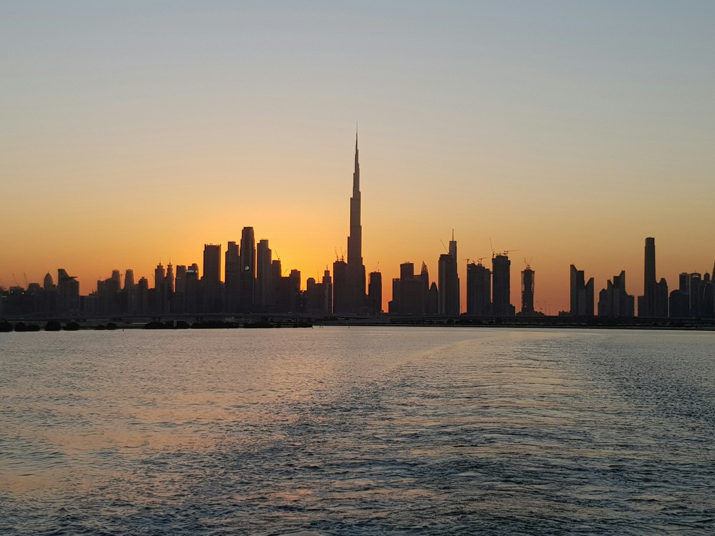 Dubai skyline at sunset with the Burj Khalifa and city lights