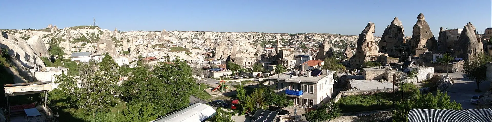 Panoramic view over Goreme village from a cave hotel terrace at golden hour