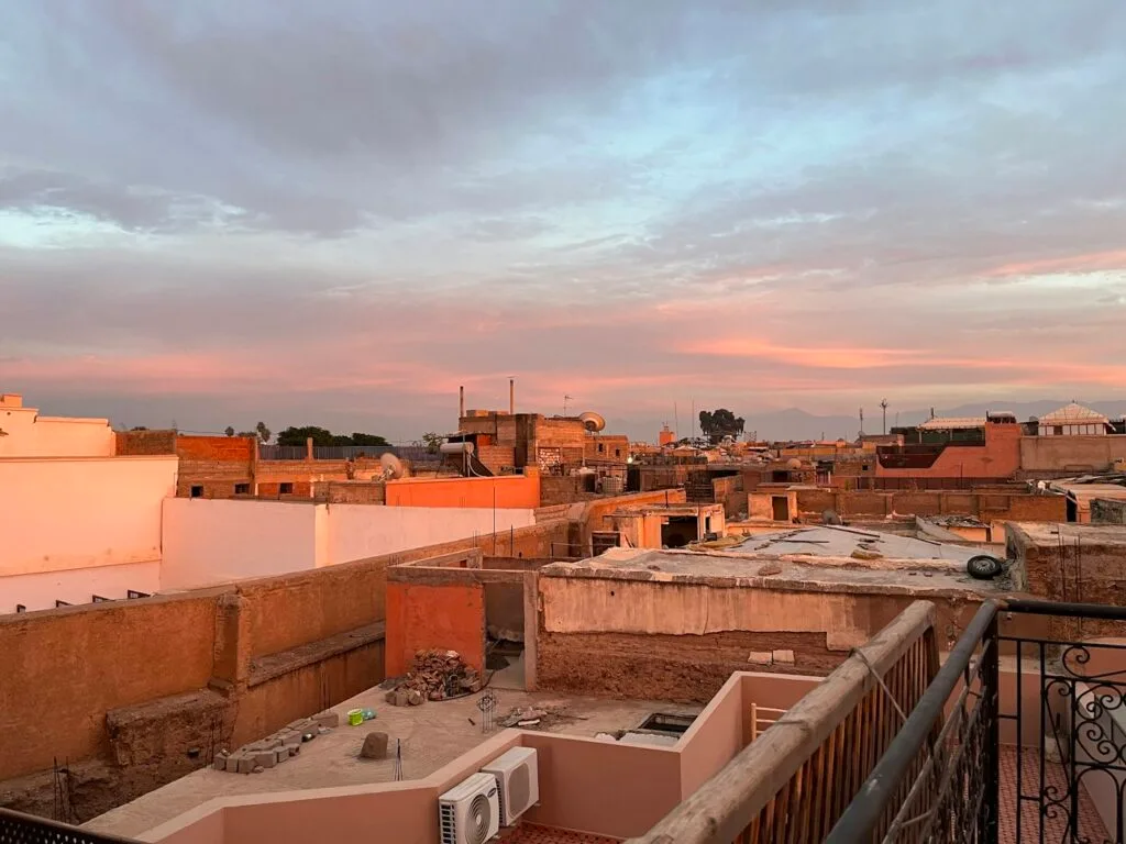Rooftop view over the terracotta rooftops and minarets of Marrakech medina at dusk