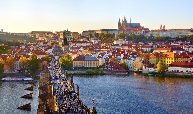 Charles Bridge and Prague Castle above the red rooftops at sunset, Czech Republic