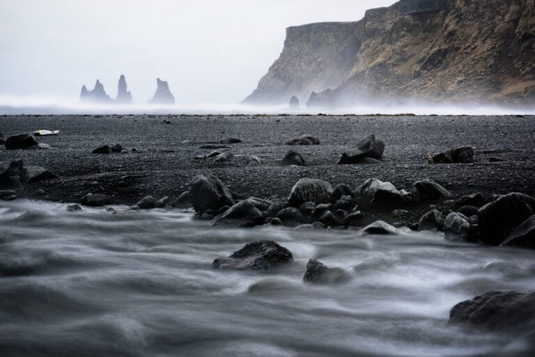Black sand beach and the Reynisdrangar sea stacks in mist, Iceland