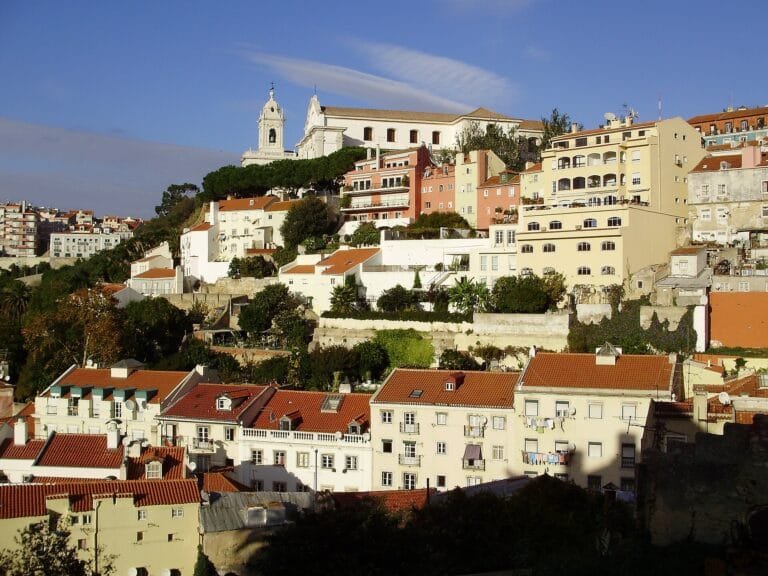 White houses with red roofs climbing a hillside in Lisbon, Portugal