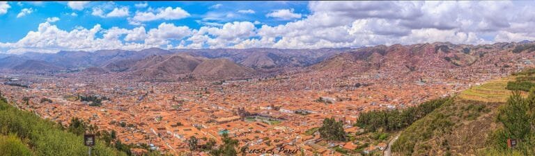 Houses spreading across dry hillsides above a valley in Peru