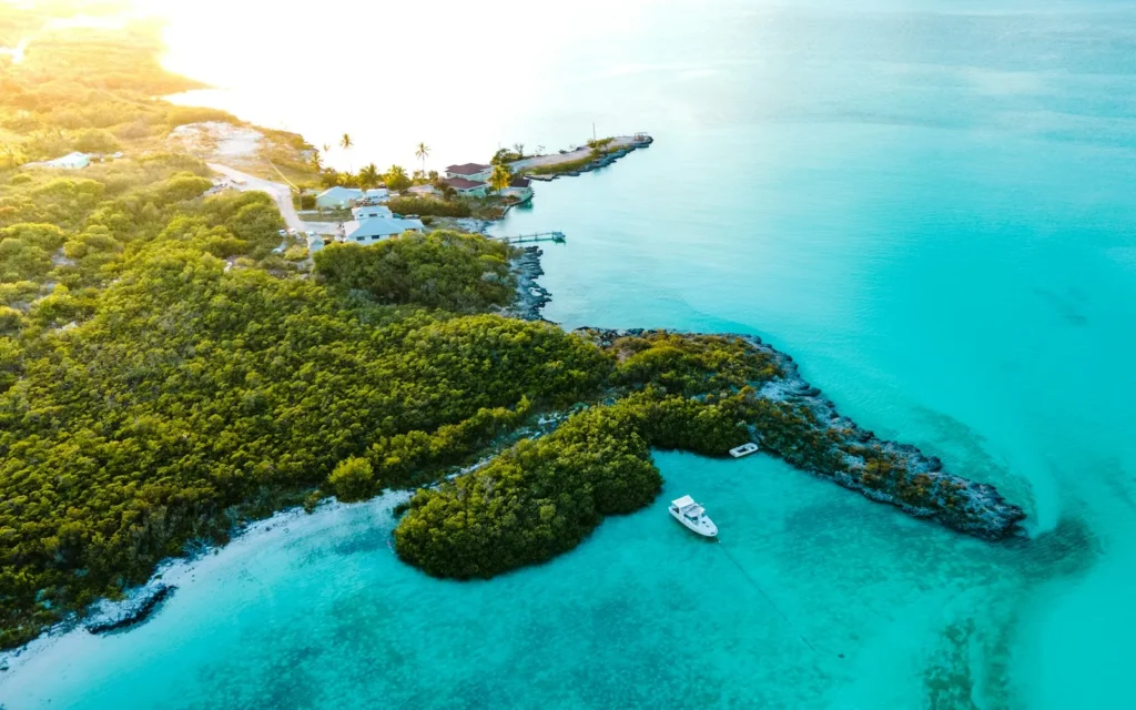 A green cay ringed by luminous turquoise water in the Bahamas