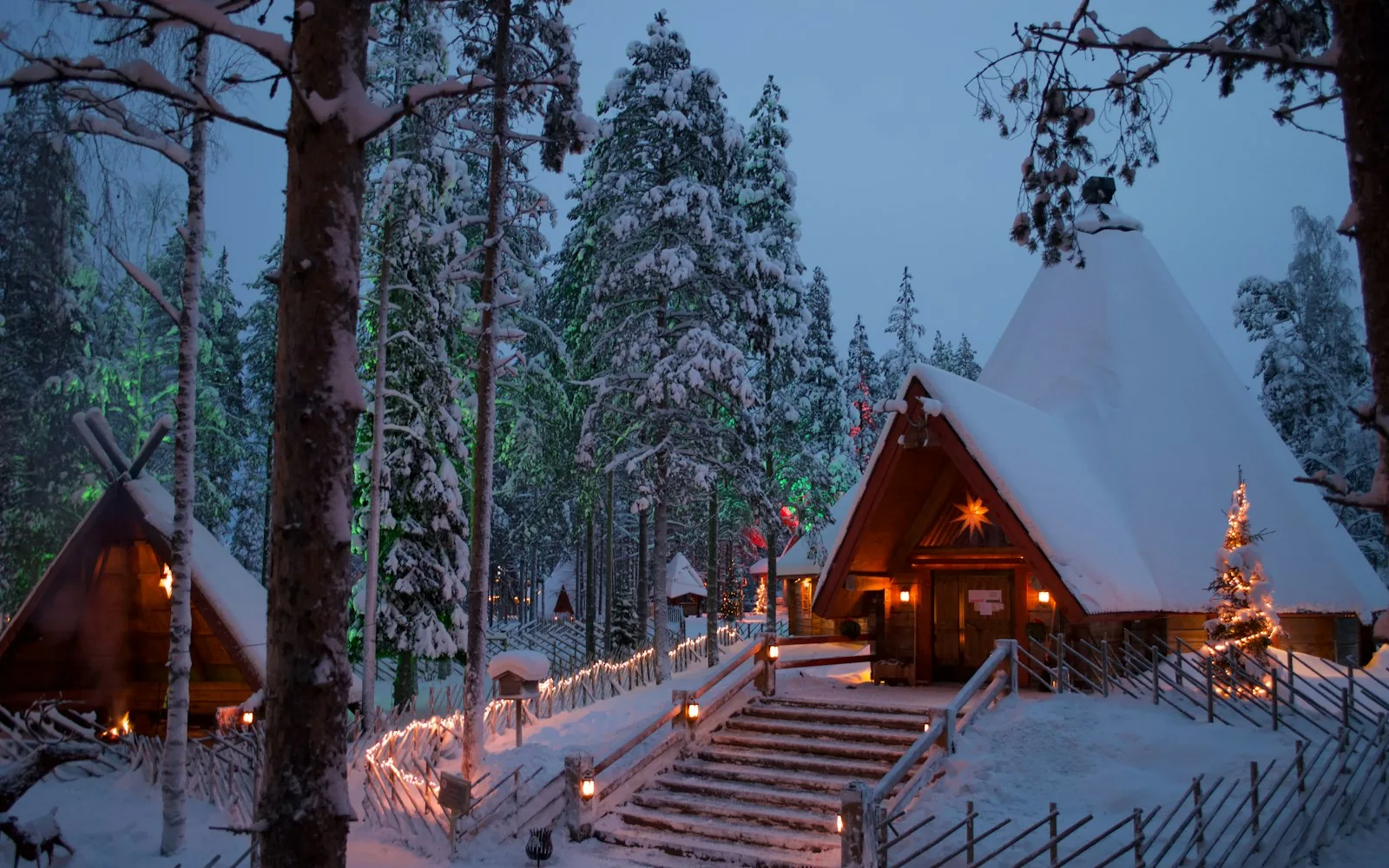 Snow-covered log cabins and Christmas lights in Rovaniemi, Finnish Lapland