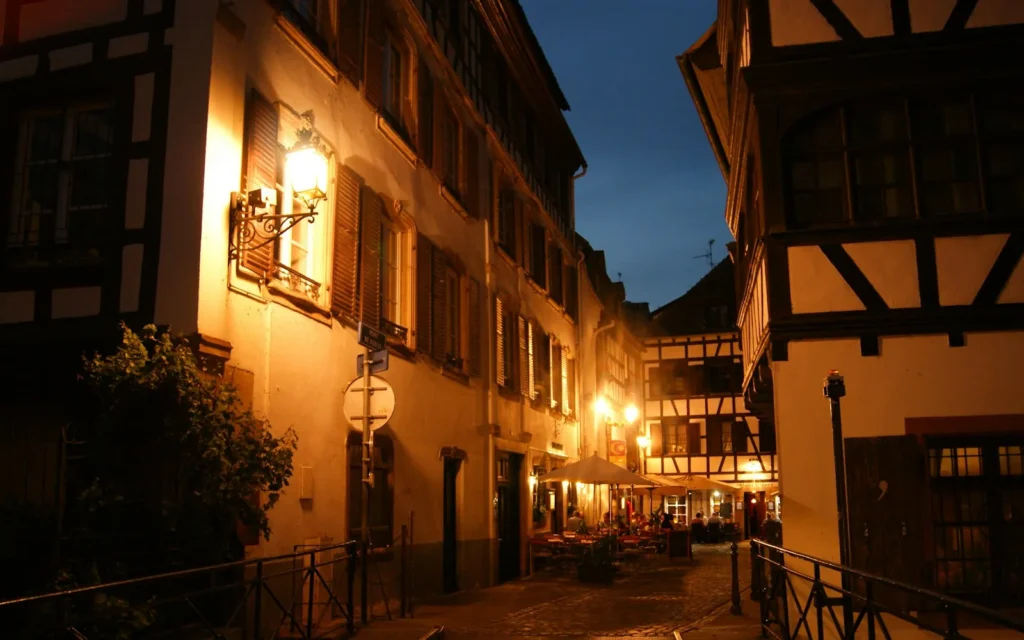 Festive lights on a half-timbered street in Strasbourg at night, France