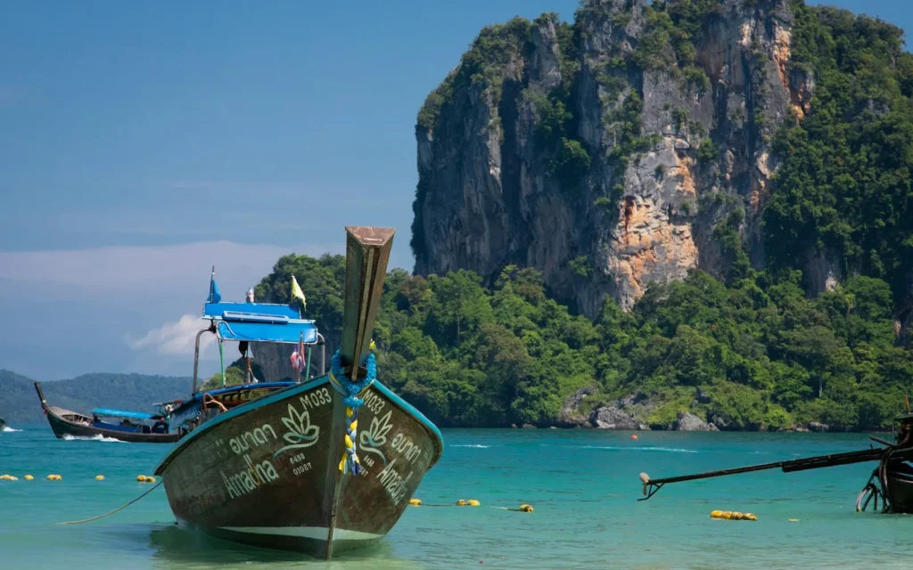 A longtail boat below the limestone cliffs of Railay Beach, Thailand