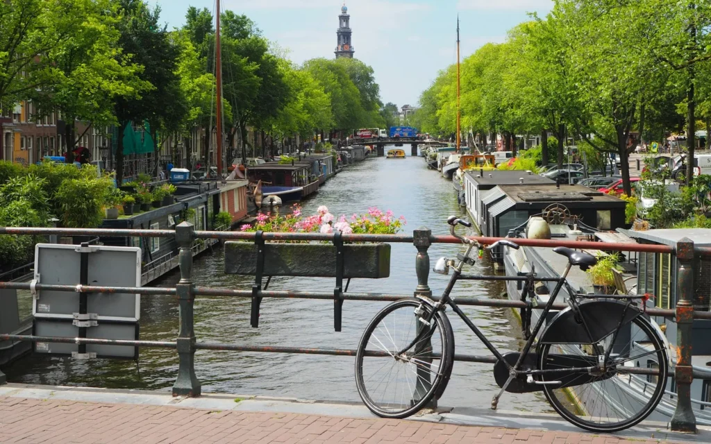 A bicycle beside a canal lined with gabled houses in Amsterdam