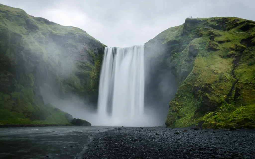 Skogafoss waterfall tumbling over green cliffs in Iceland