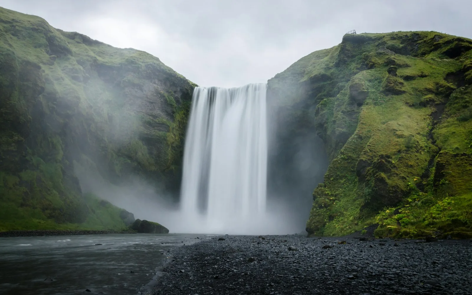 Skogafoss waterfall tumbling over green cliffs in Iceland