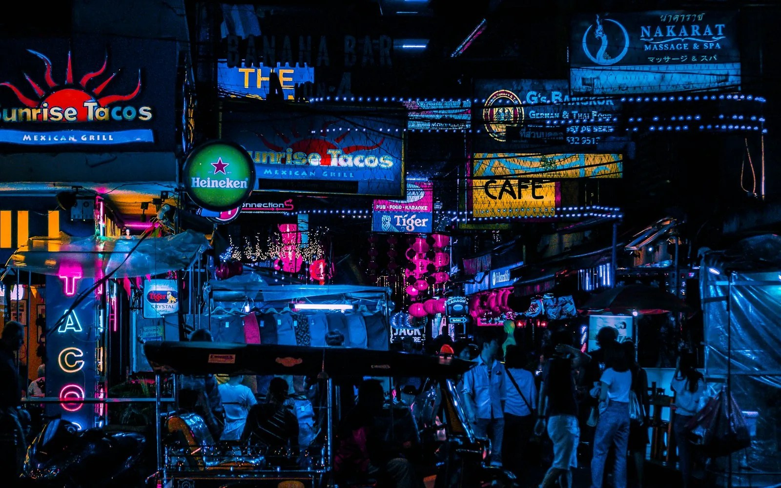 Neon-lit street-food stalls at a night market in <a href=
