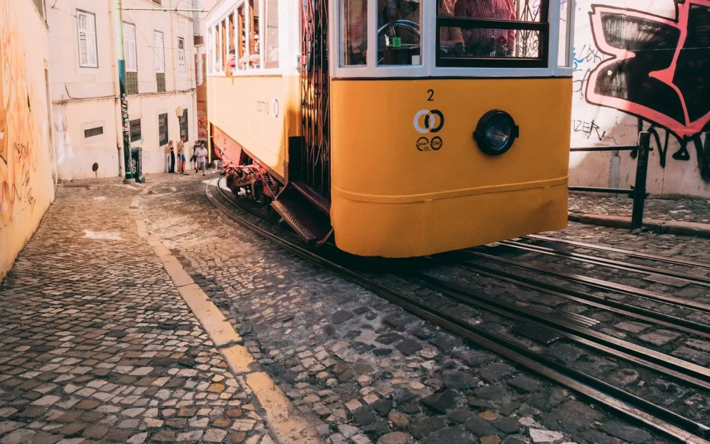A yellow tram climbing a steep street in Lisbon, Portugal