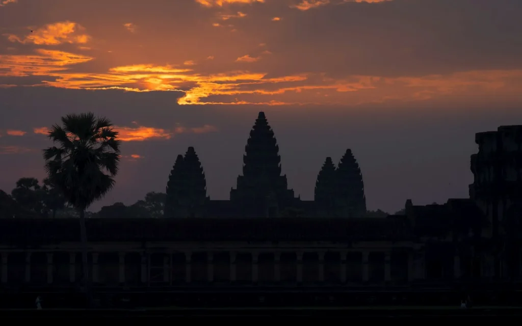 The silhouetted towers of Angkor Wat against a fiery sunset sky, Cambodia