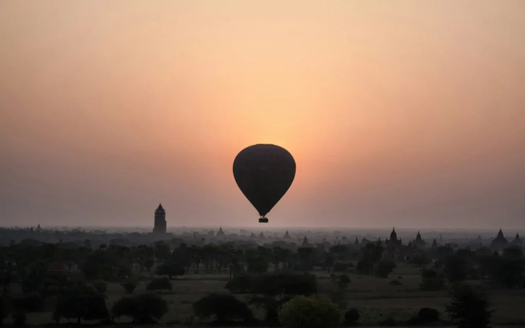 A hot-air balloon over the ancient temple plain of Bagan, Myanmar at golden hour