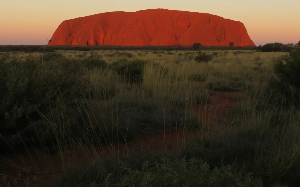 Uluru glowing deep red at sunset in the Australian outback