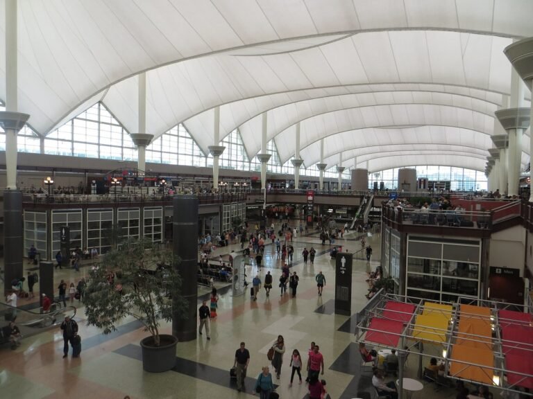 Travellers inside the Jeppesen Terminal great hall at Denver International Airport, under its white tented roof