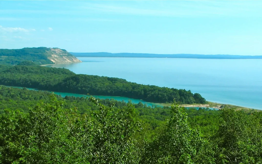 Forested dunes above the blue water of Lake Michigan at Sleeping Bear Dunes